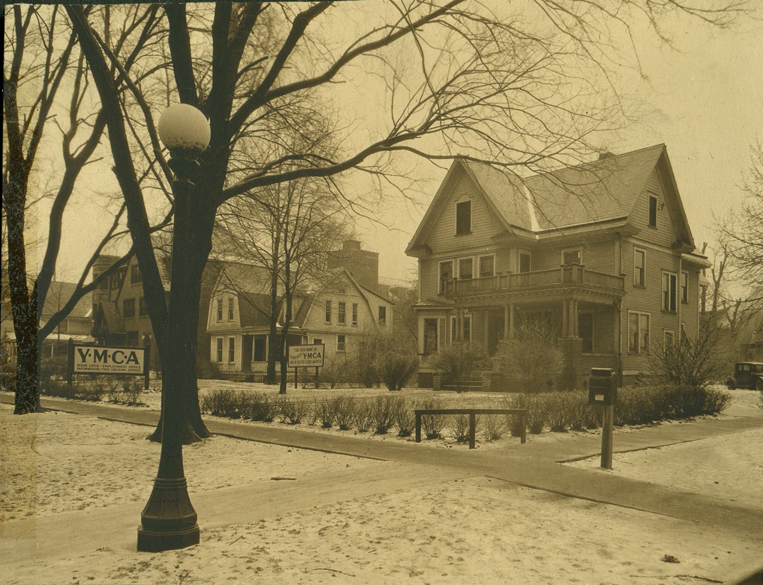 The University YMCA's temporary home at Wright and Chalmers streets, c. 1928–32. The sign at left reads "Room Lists – Employment Office – Information – Free Checking Service."