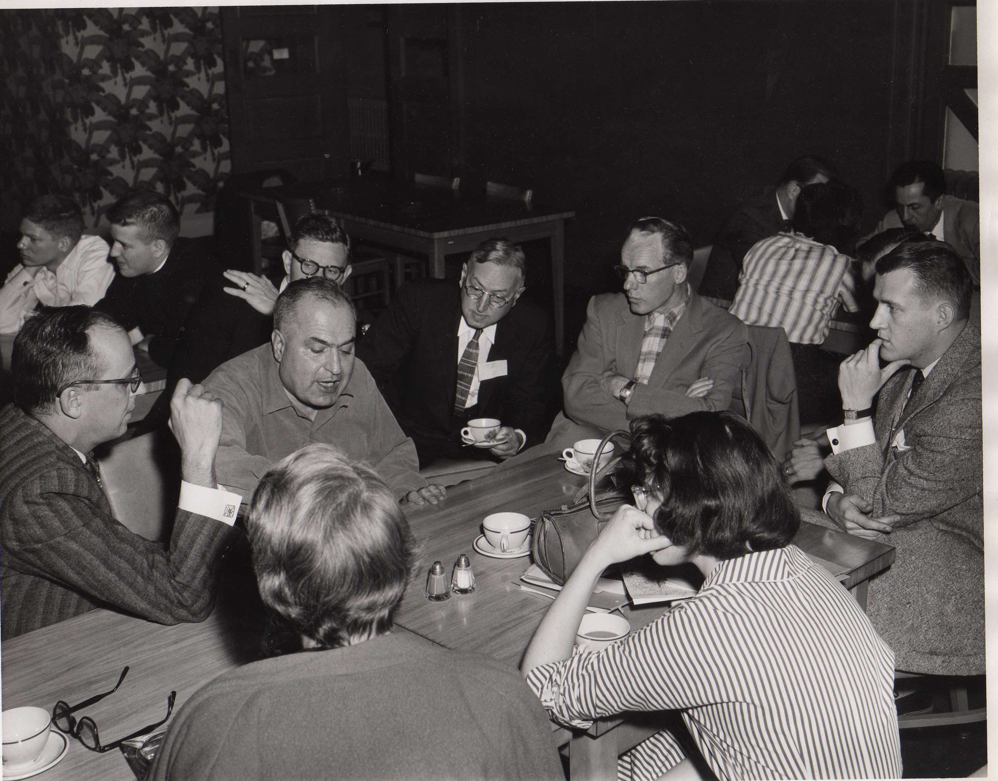 John Price (arms folded, fourth from left) listens as the theologian Will Herberg (second from left) talks with students and staff, December 1957. University YMCA photograph.