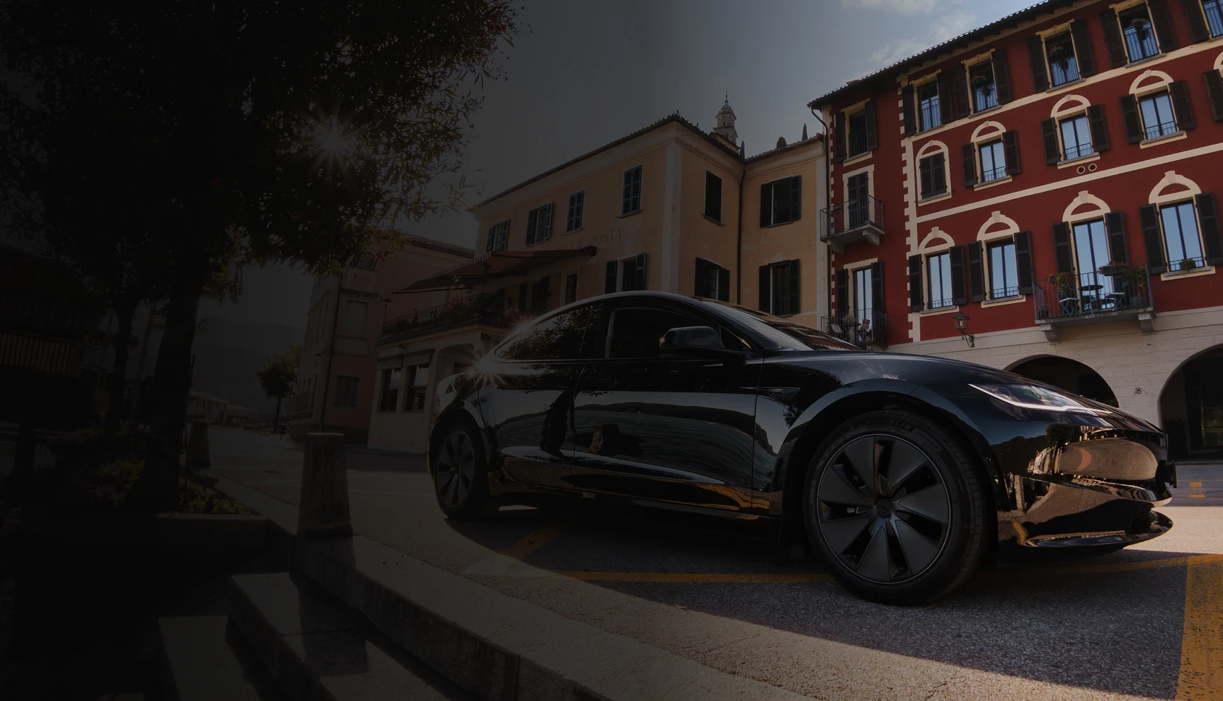 Autista donna con Tesla nera davanti a hotel di lusso in Ticino