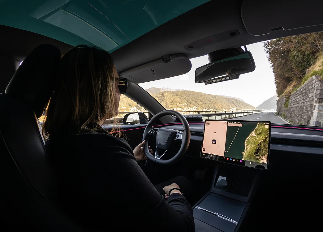 Autista donna al volante di taxi Tesla lungo il Lago di Lugano