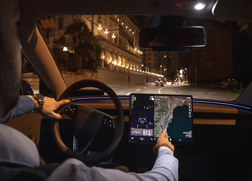 Autista taxi Tesla di notte a Lugano con touchscreen navigazione attivo
