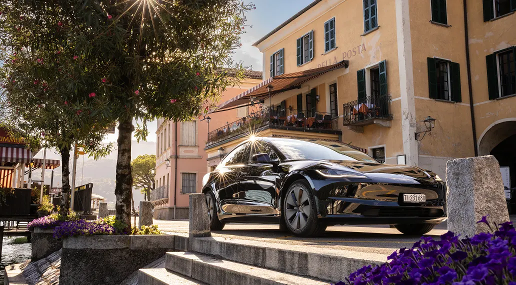 Taxi Tesla Model 3 nera in piazza lacustre in Ticino