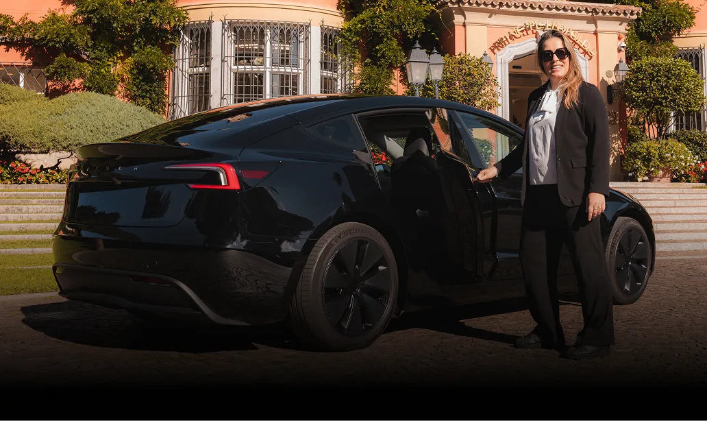 Autista donna apre portiera Tesla nera davanti a hotel di lusso in Ticino