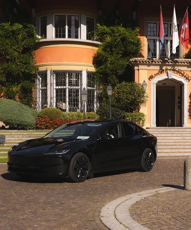 Tesla taxi nera parcheggiata davanti a hotel di lusso in Ticino