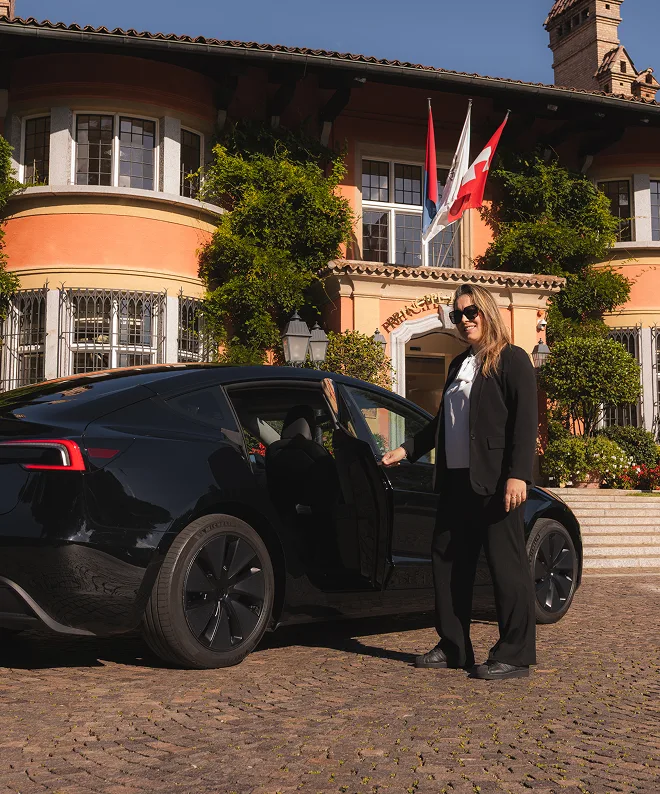 Autista donna con Tesla nera davanti a hotel di lusso in Ticino