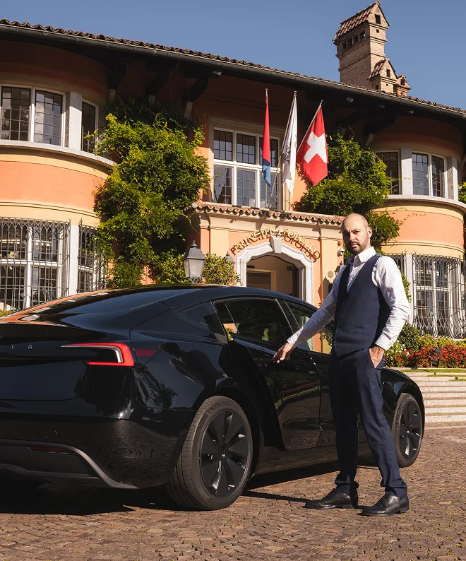 Autista privato apre portiera Tesla nera davanti a villa in Ticino