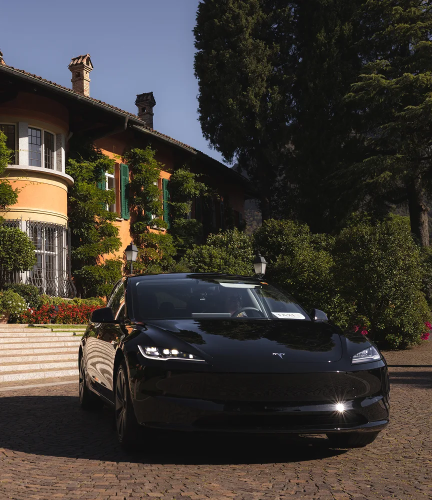 Tesla taxi Lugano parcheggiata davanti a villa storica di lusso in Ticino