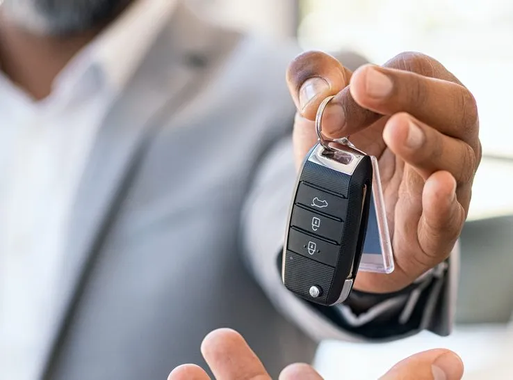 Hand holding out a car key