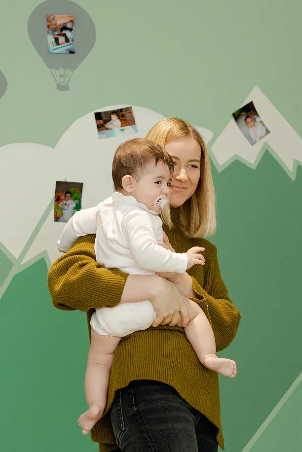 Une professionnelle souriante tient un bébé dans ses bras