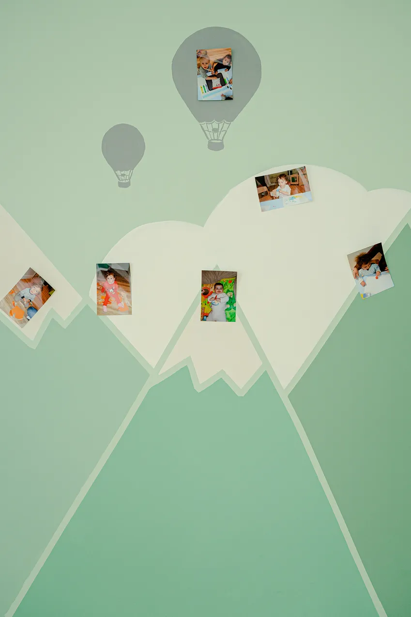 Mur peint de montagnes et de montgolfières, avec les photos des enfants