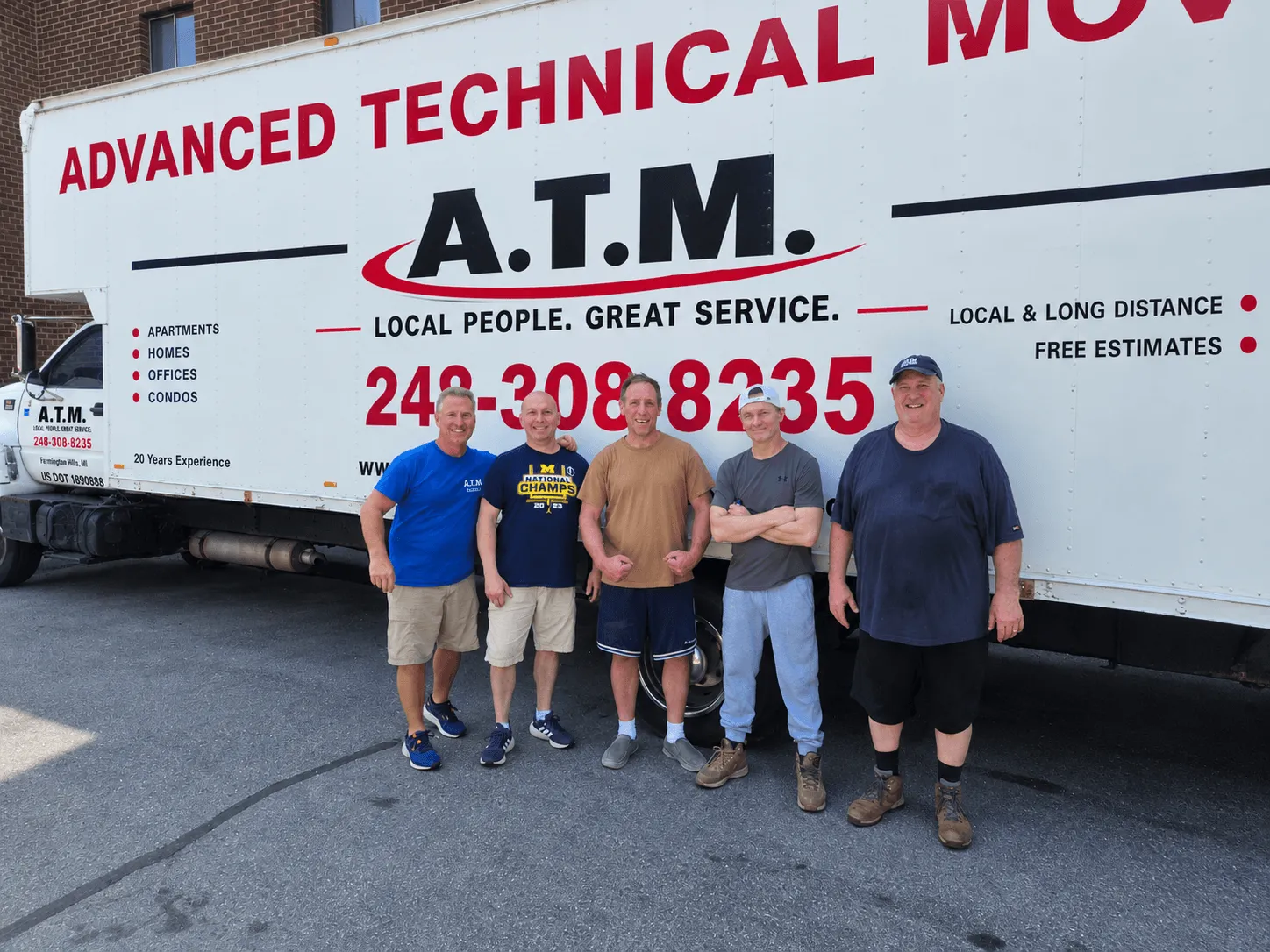 Two Advanced Technical Moving trucks loading outside a commercial building