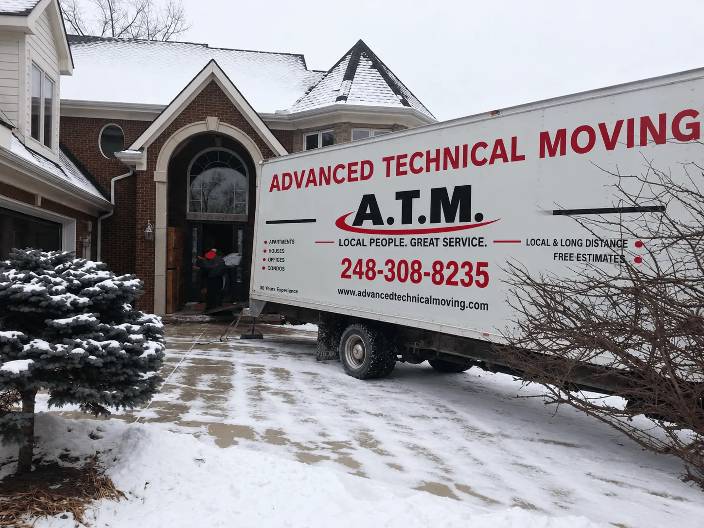 Advanced Technical Moving truck backed up to a brick home on a snowy winter day