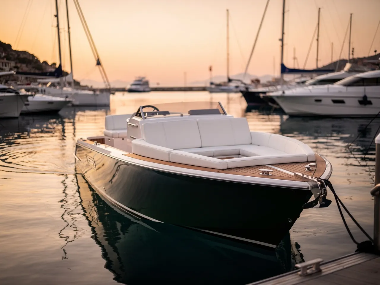 An open day boat with white upholstery in a marina at sunset