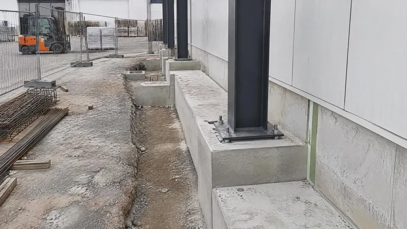 Joint vertical en matériau compressible entre le soubassement de l'existant et le béton neuf d'une extension industrielle