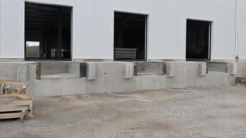 Fosse de niveleur coulée dans un mur de quai en béton, cornières d'acier aux arêtes et butoir béton voisin