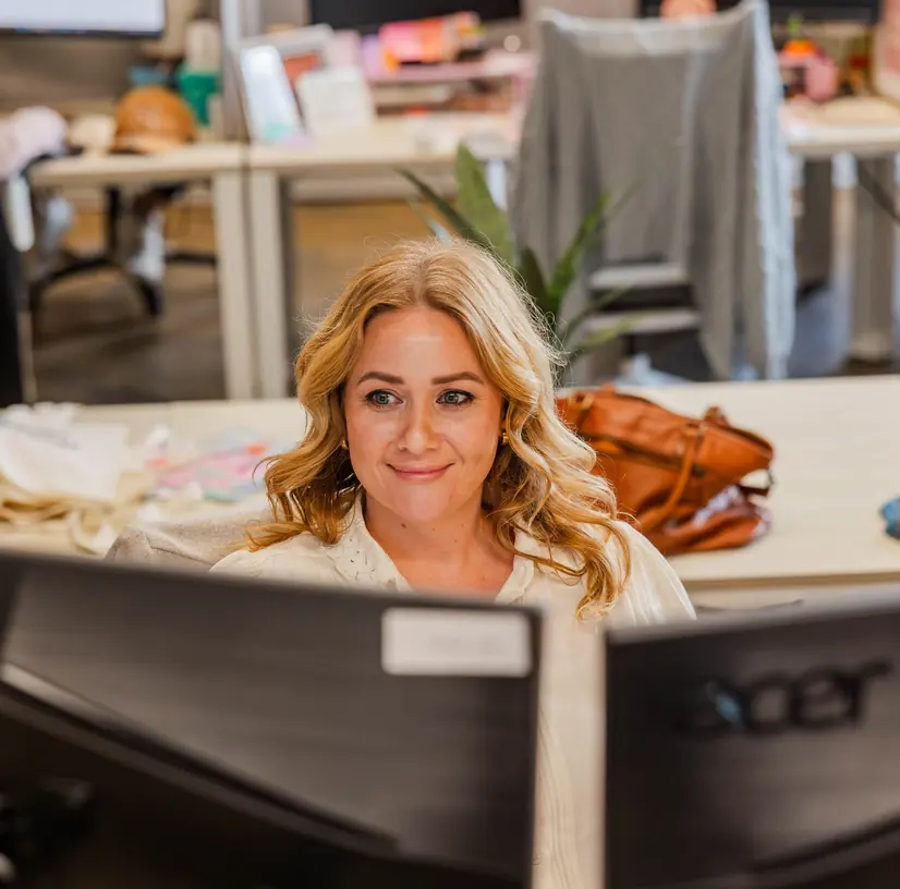 A smiling Cookie Finance team member at her desk