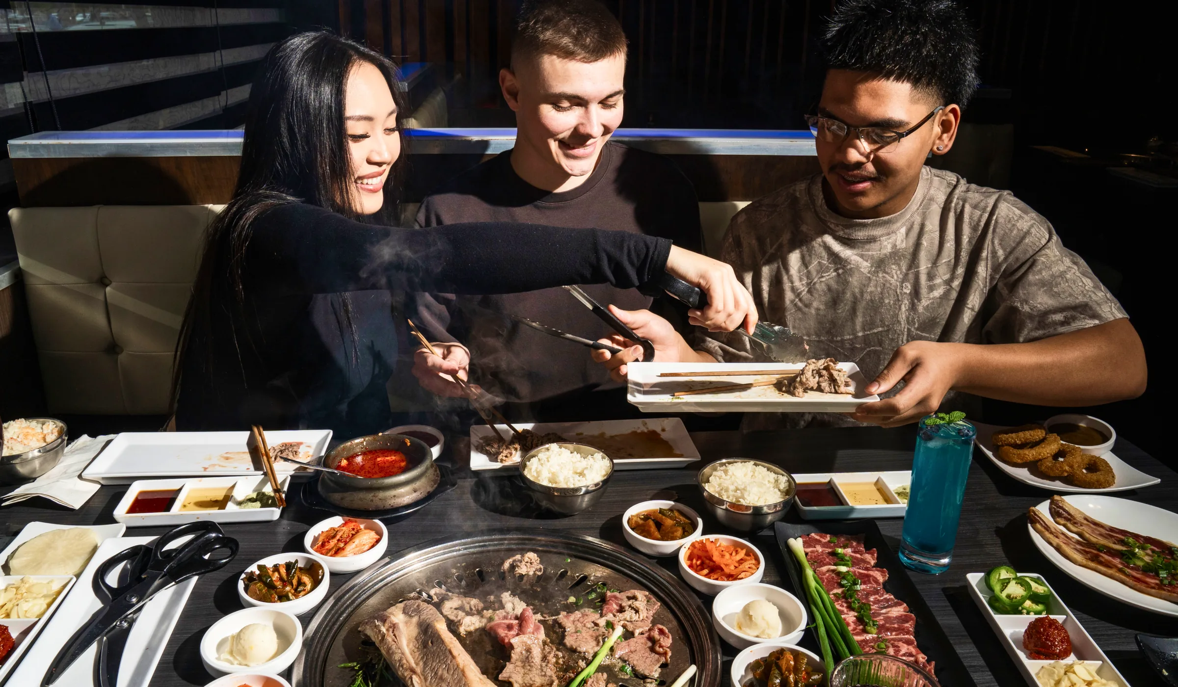 Three friends grilling together at a GEN table