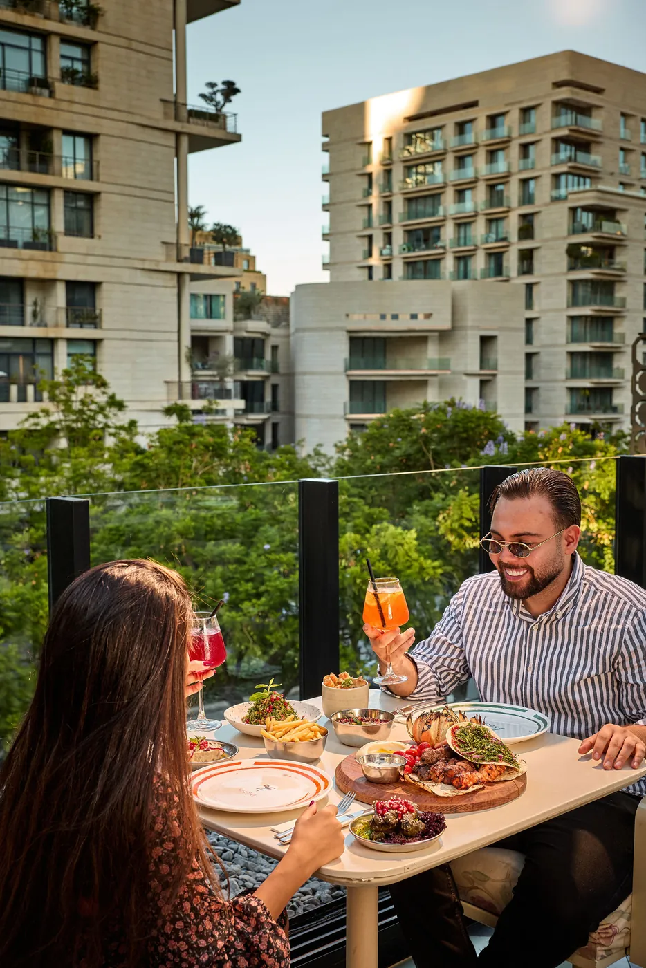 A couple toasting at sunset on the terrace