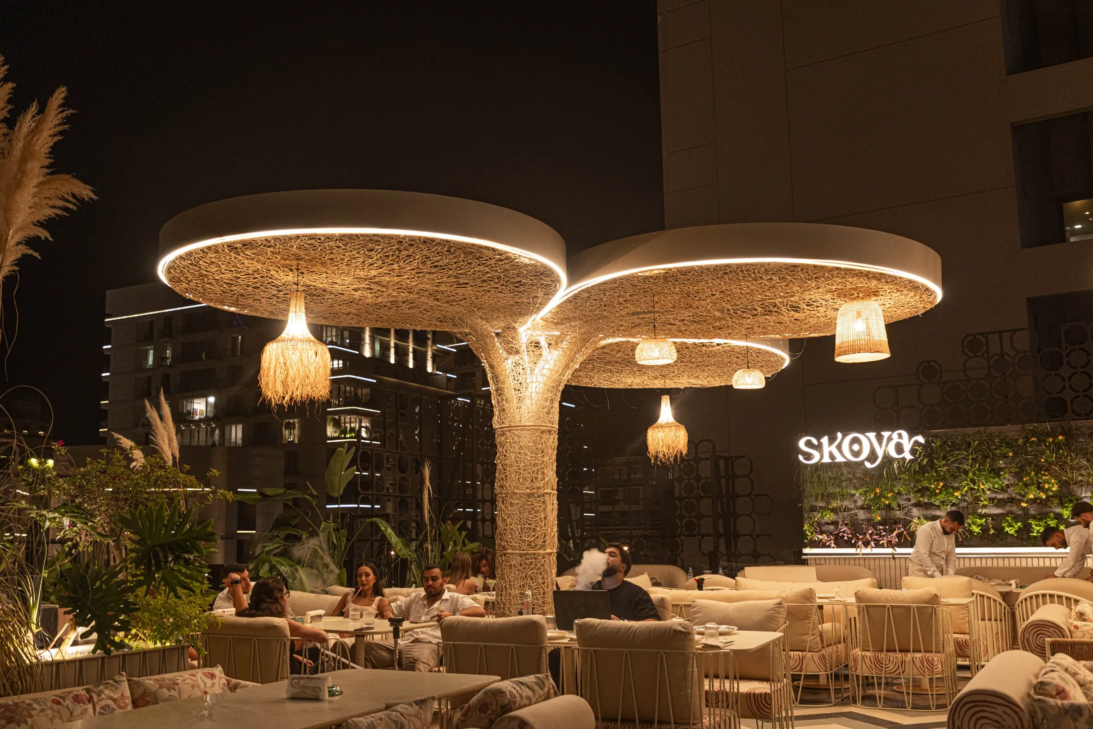 The rooftop at night under the glowing woven canopies