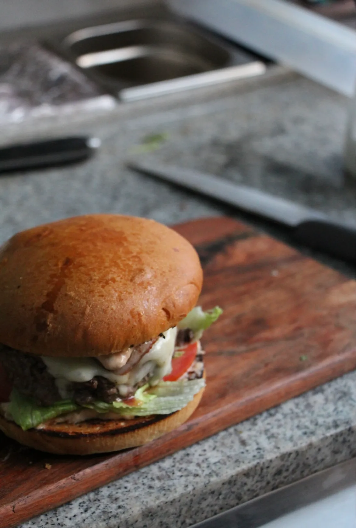 Burger maison dressé sur planche en bois, Du Tout Cuit traiteur à Montpellier