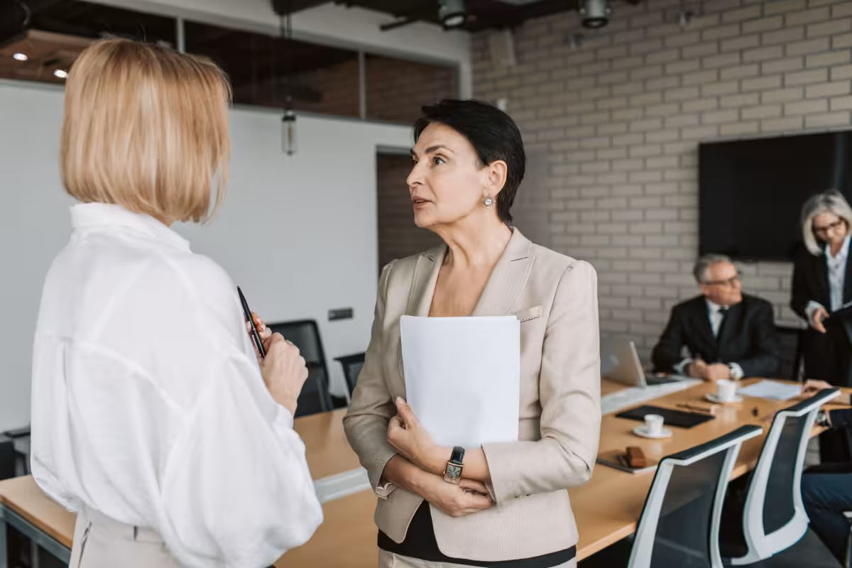 Zwei Kolleginnen besprechen sich stehend im Büro