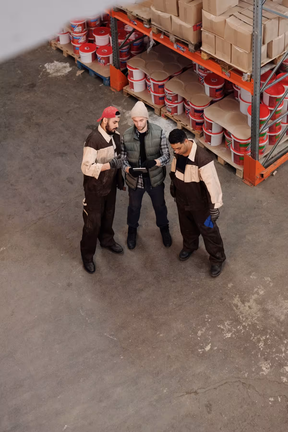 Drei Lagermitarbeiter besprechen sich in einer Lagerhalle