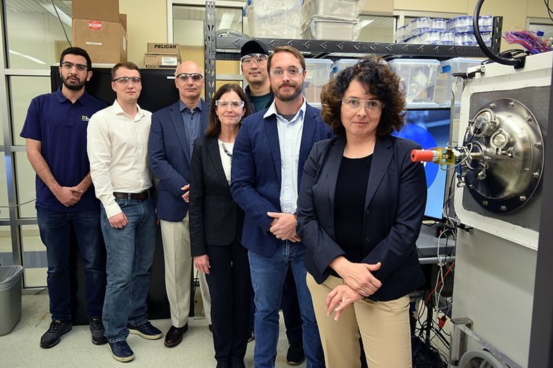 Purdue research team standing beside a freeze dryer in the lab