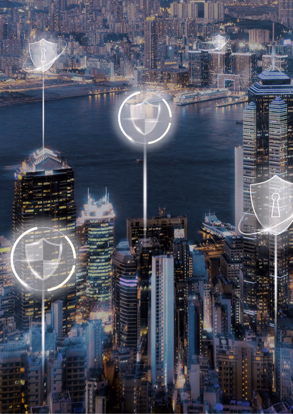 Nighttime cityscape with illuminated skyscrapers and digital shield icons symbolizing cybersecurity over buildings.