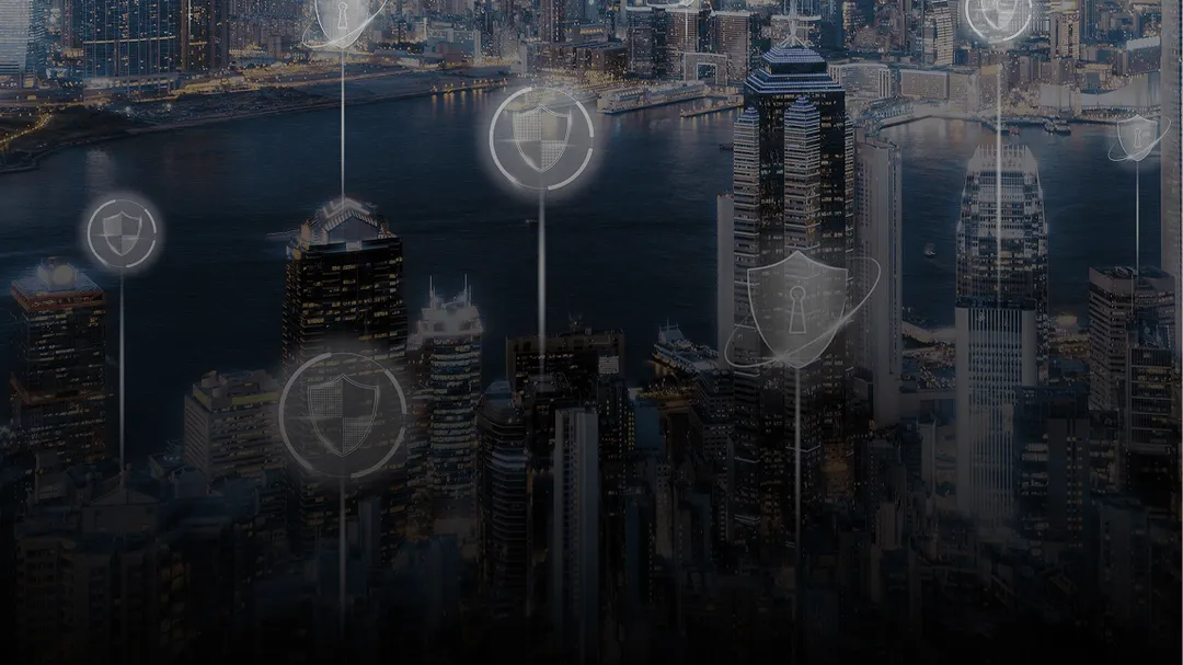 City skyline at night with illuminated buildings and digital security shield icons overlay.