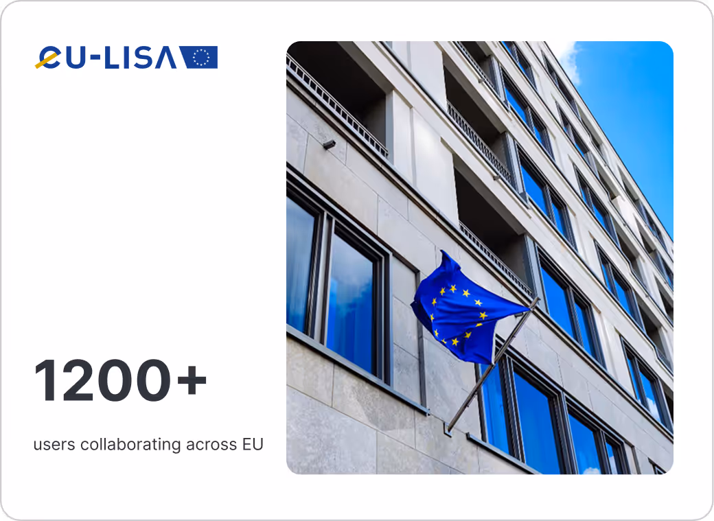 European Union flag waving outside a modern office building with reflective blue windows.