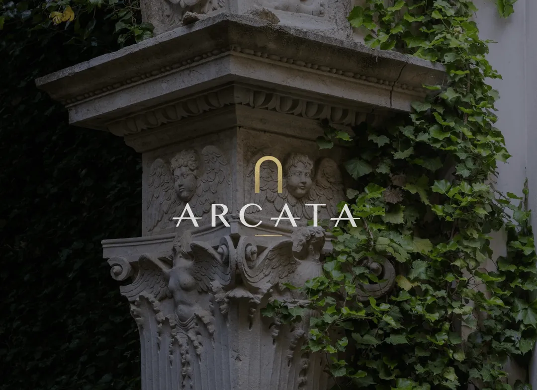Arcata arch logo and wordmark over an ivy-covered carved stone capital.