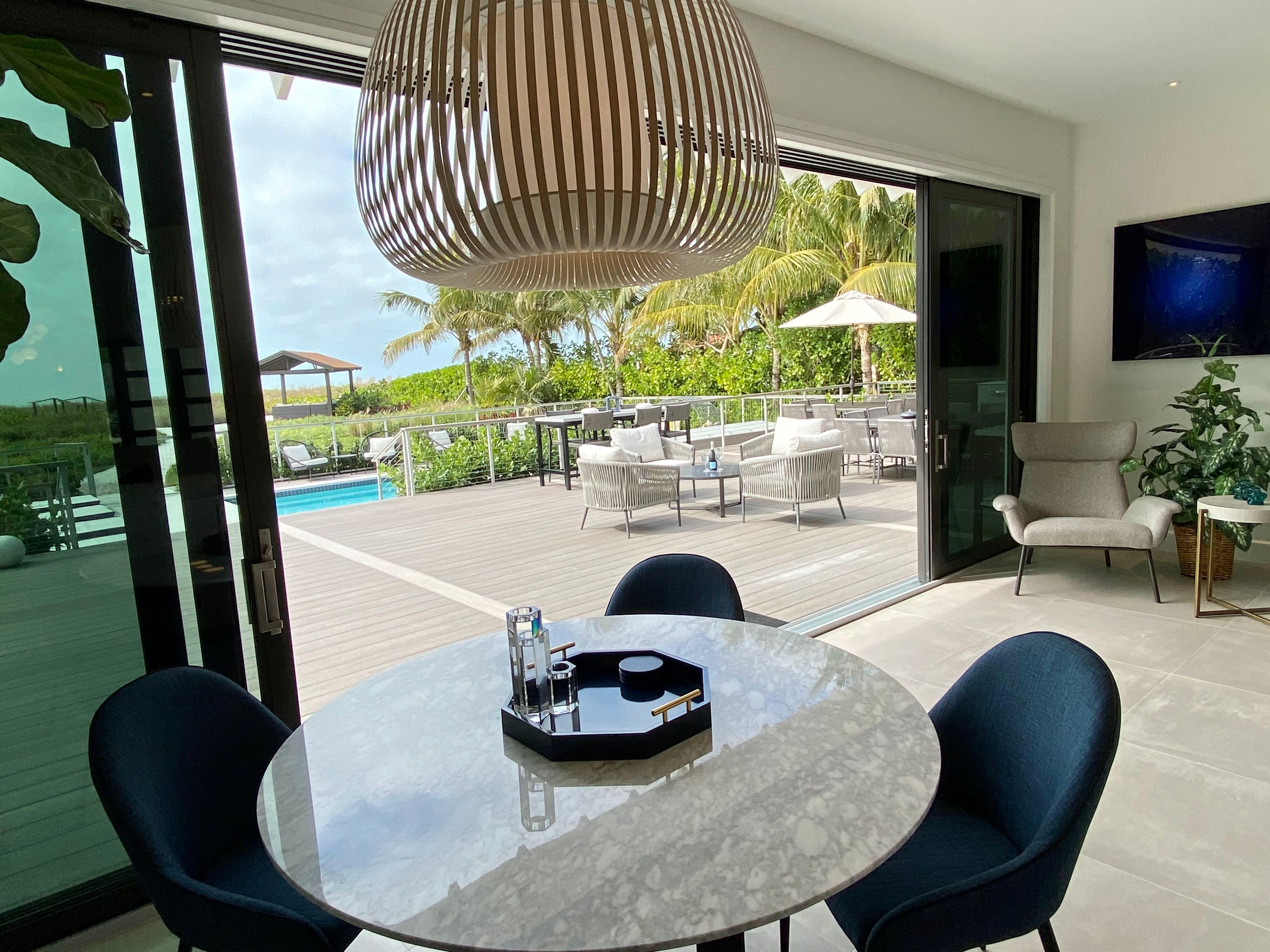 View through open glass doors to the pool and the Gulf