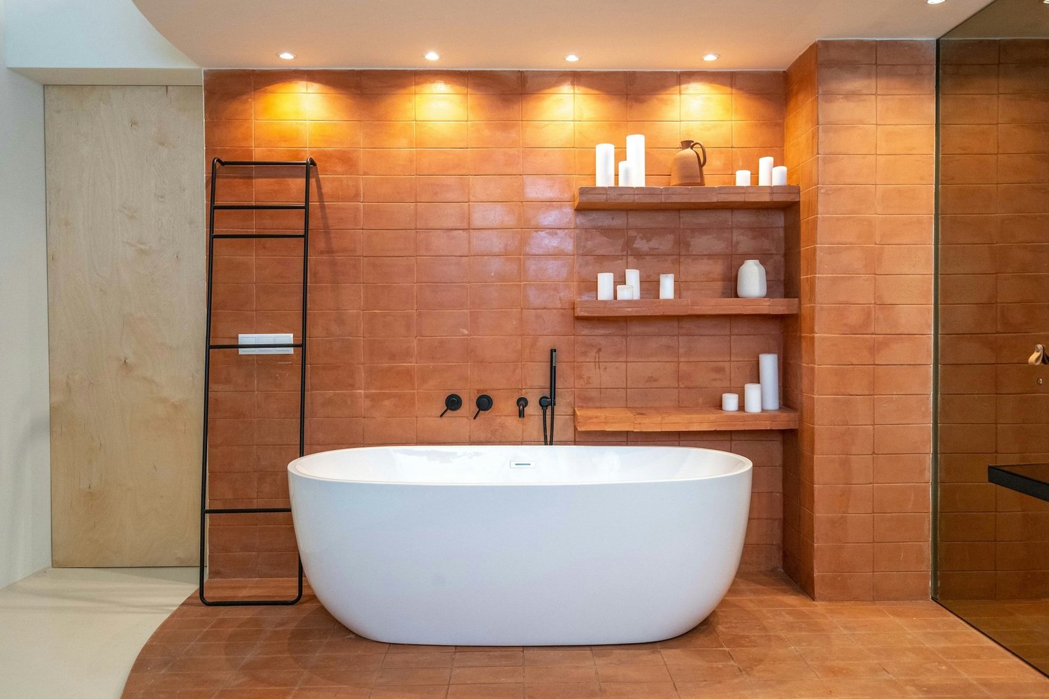 Freestanding tub in a terracotta-tiled luxury bathroom