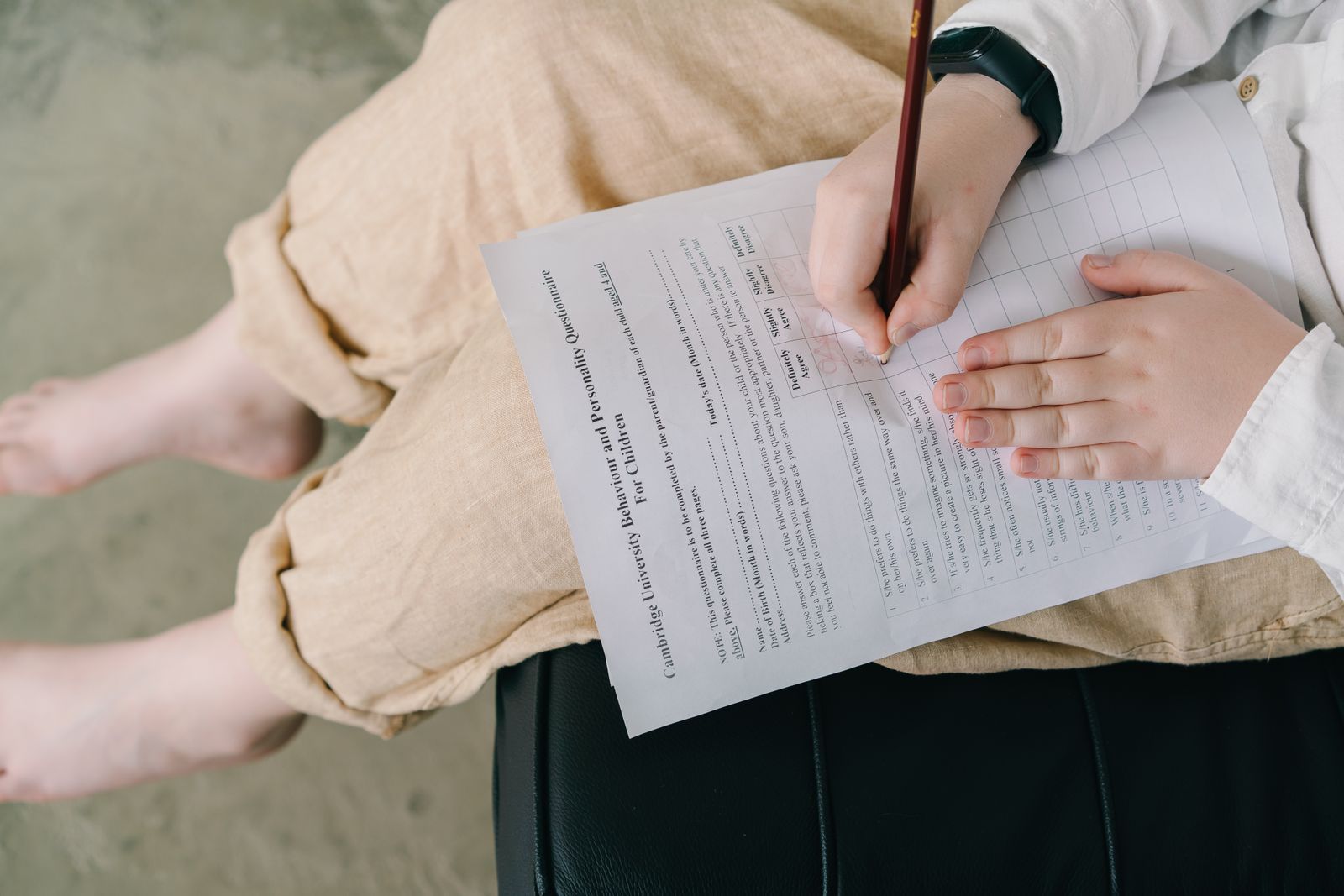 A child filling out a questionnaire with a pencil during a psychological assessment