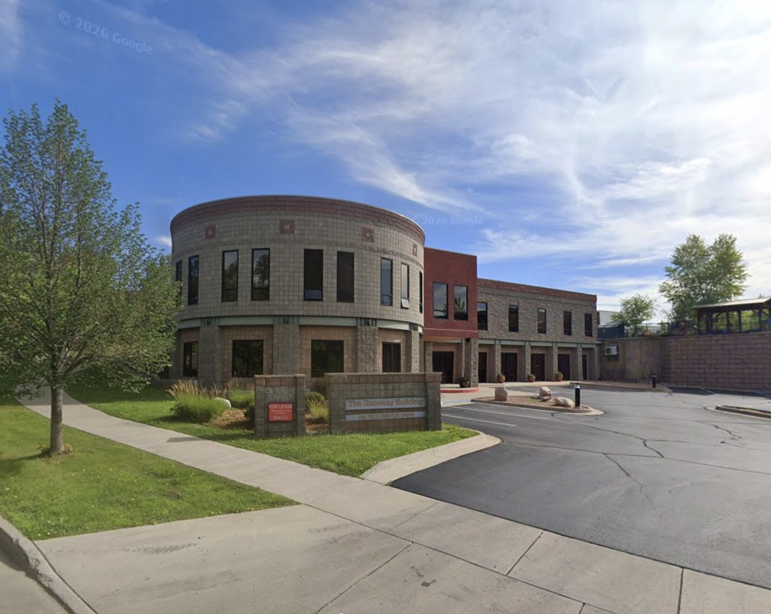 The Gateway Building, home of the Durango office, with a round stone tower and parking lot