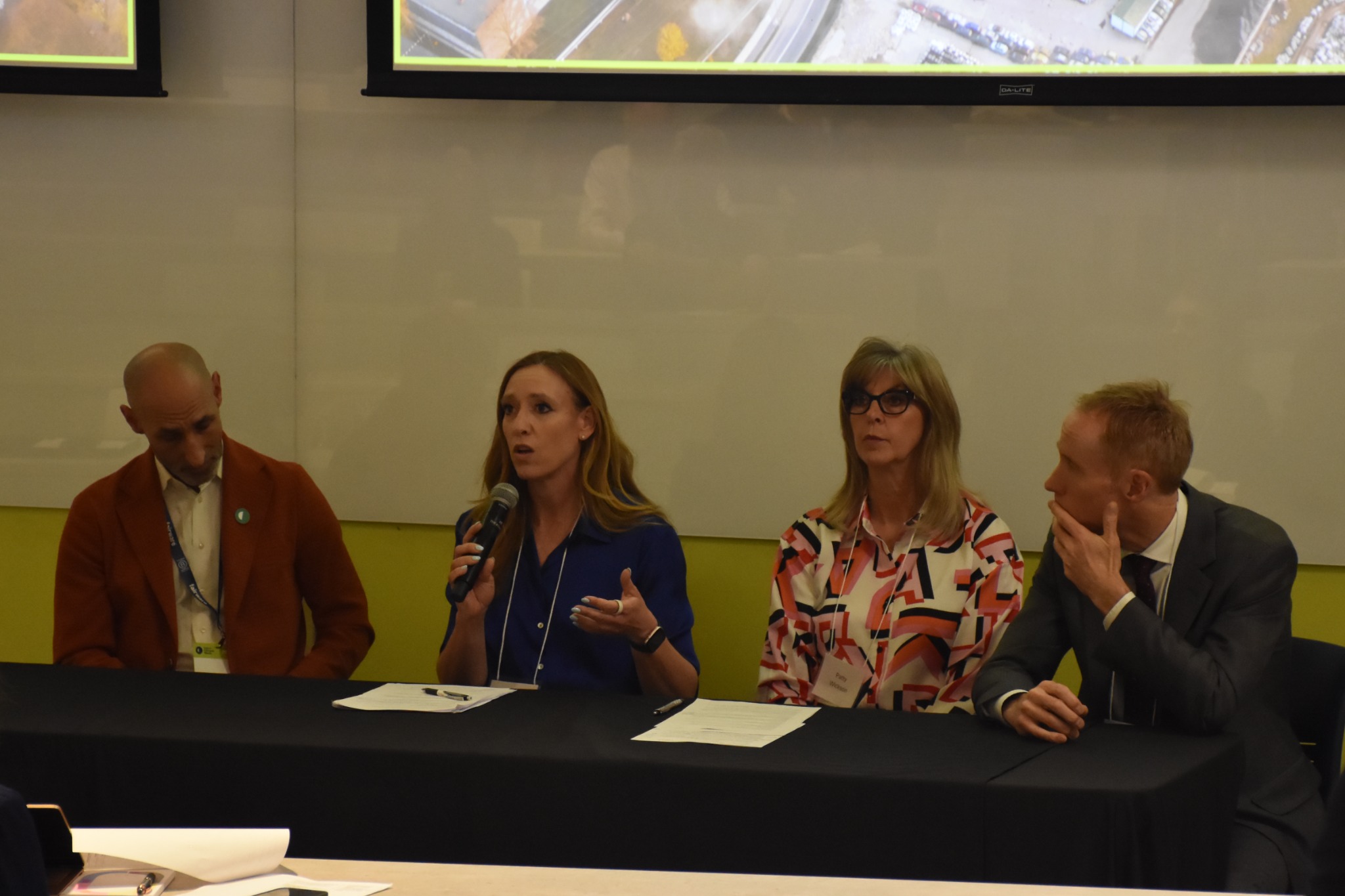 Stacey Litvinchuk speaking into a microphone during a conference panel discussion