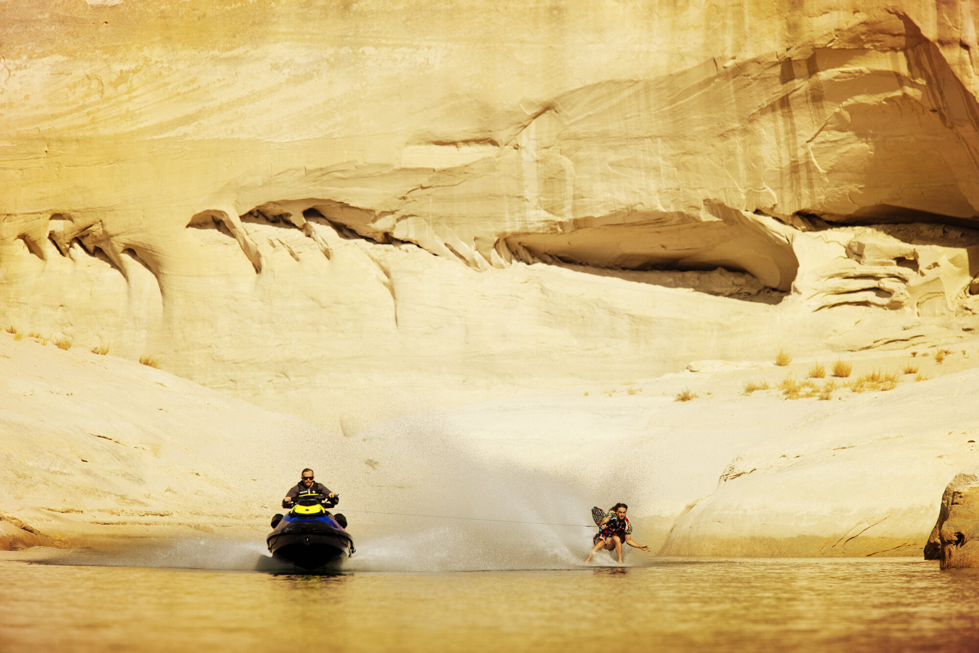 Sea-Doo towing a wakeboarder past sandstone canyon walls at Lake Powell