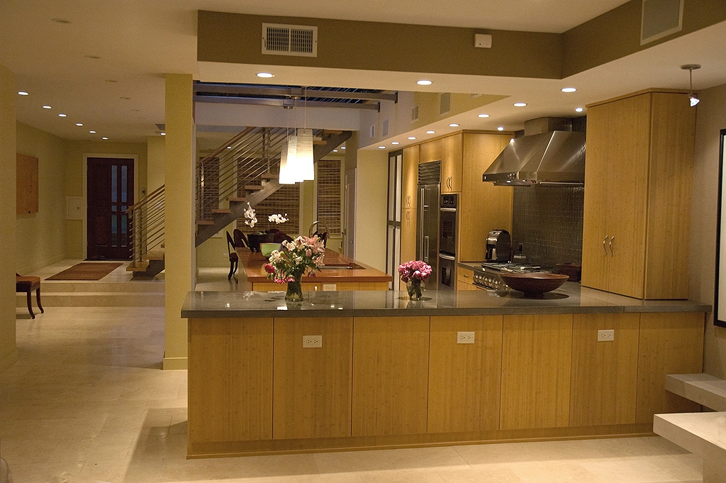Chicago Townhouse kitchen with wood cabinets, a long island, and a view toward the staircase
