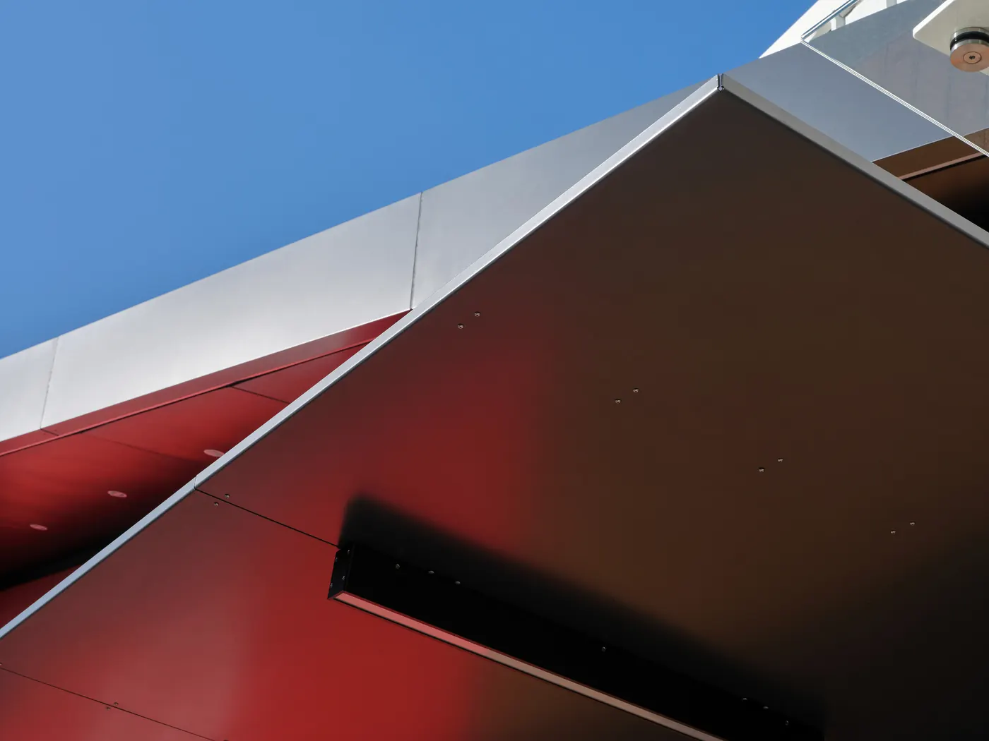 The red shopfront reflected in the canopy's underside