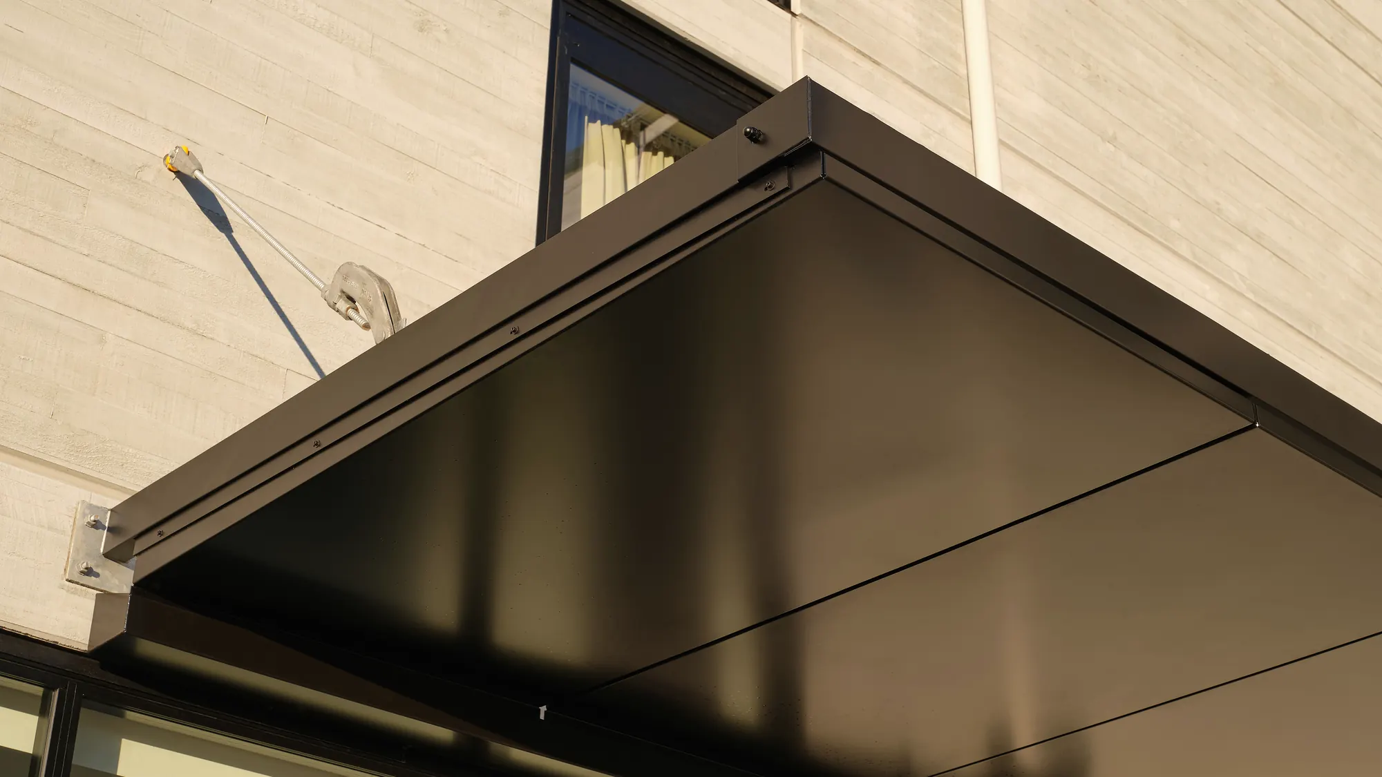 The canopy's corner and a tie rod over the glazed entrance