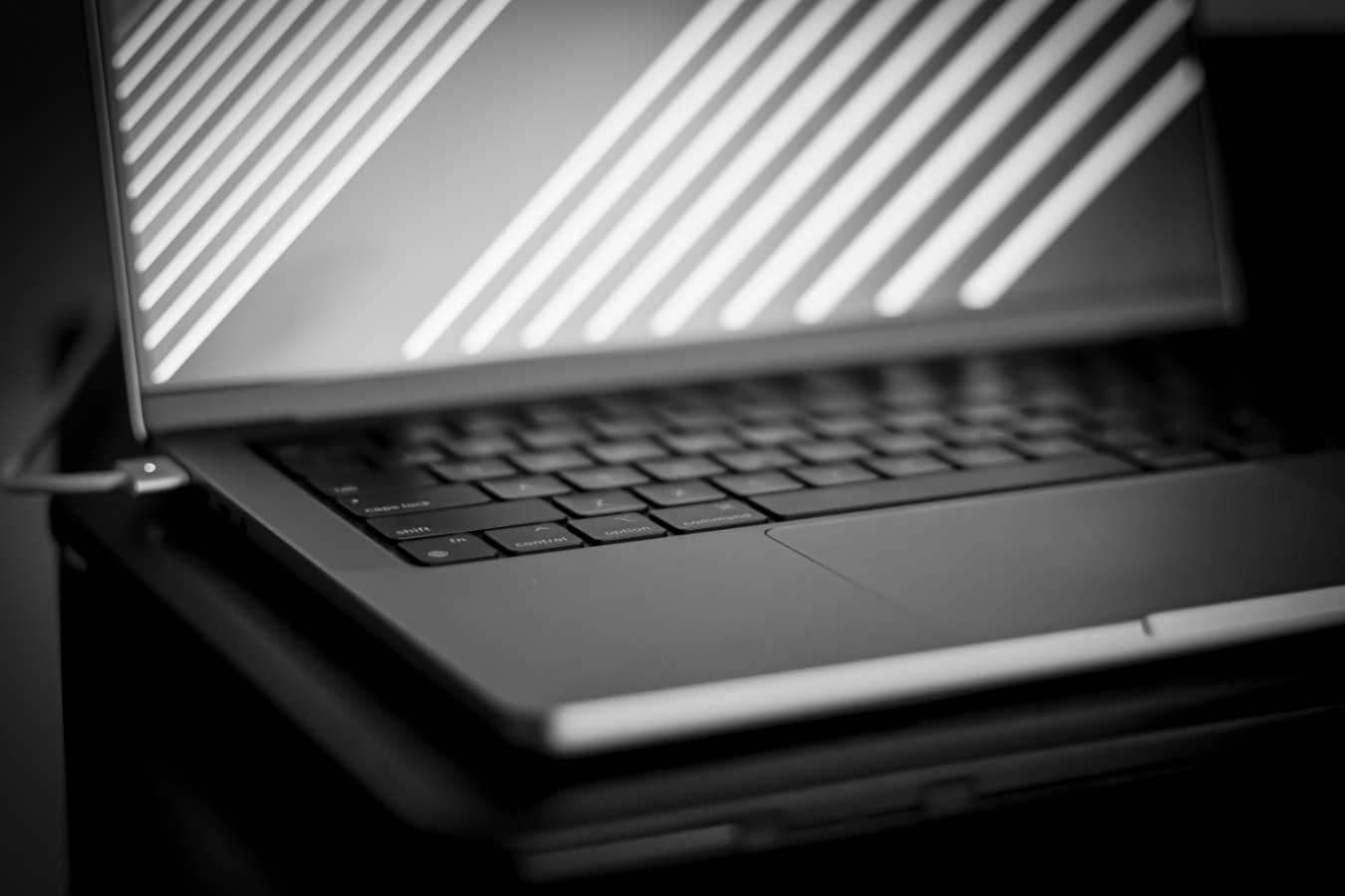 Zwart-witdetail van een geopende laptop met lichtstrepen op het scherm