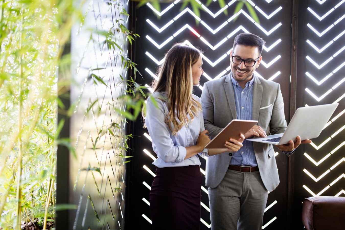 Man en vrouw bespreken tablet en laptop staand buiten