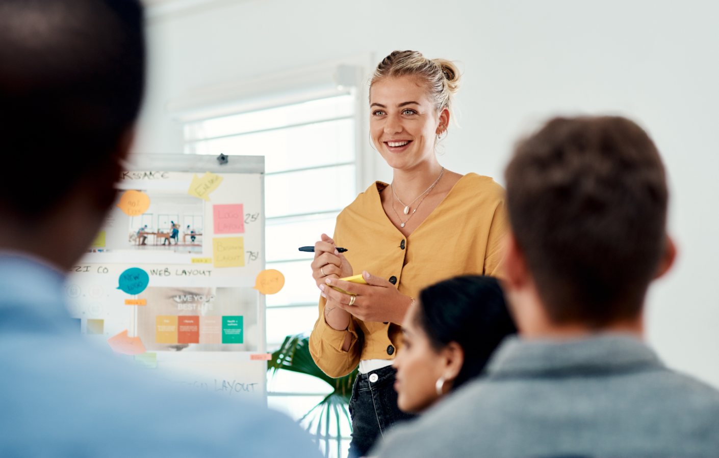 Vrouw geeft presentatie met flip-over aan groep collega's