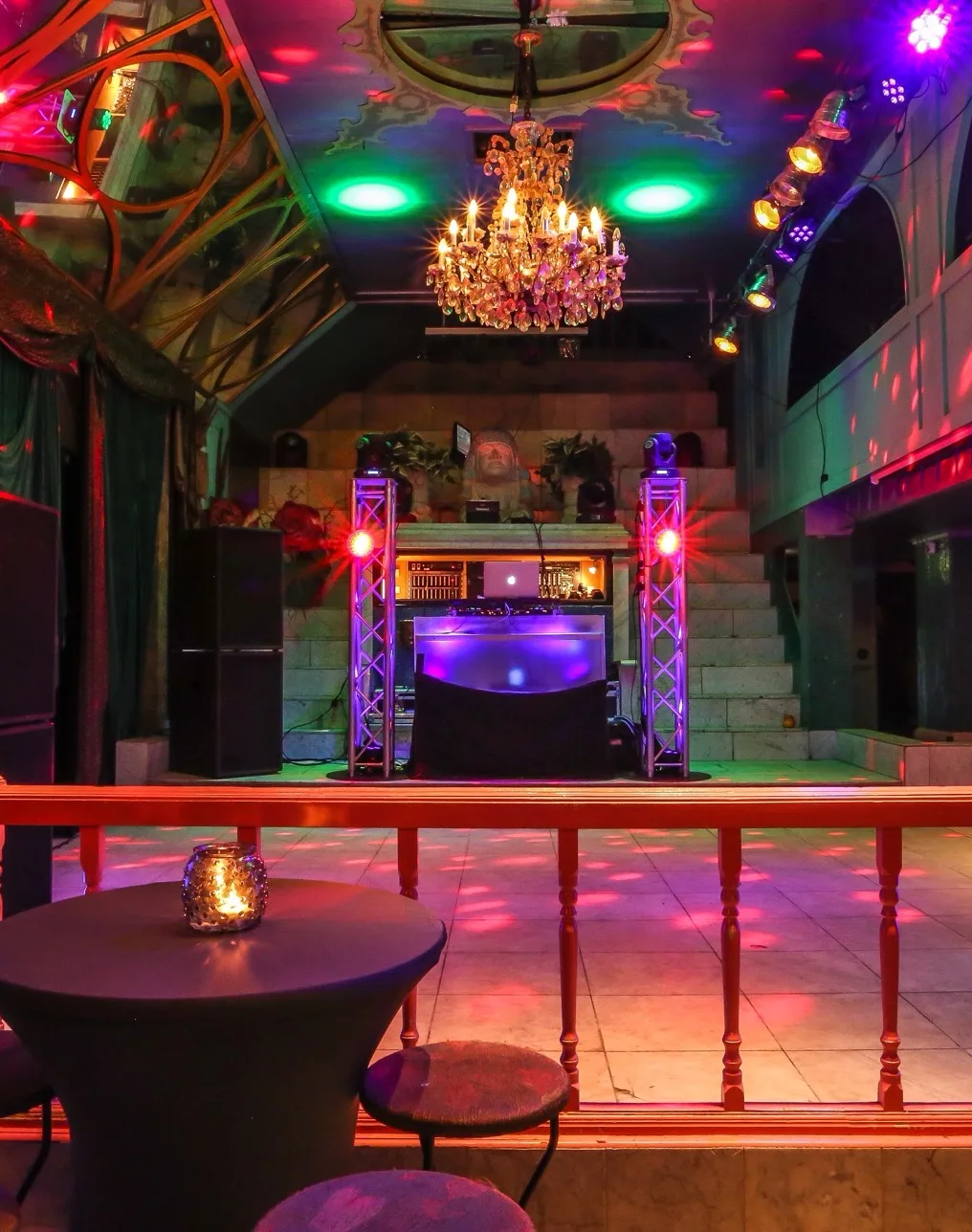 Feestzaal met dansvloer, dj-tafel en kroonluchter