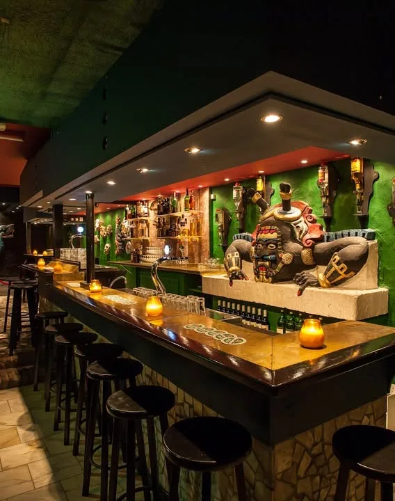 Bar met beelden en een groene wand