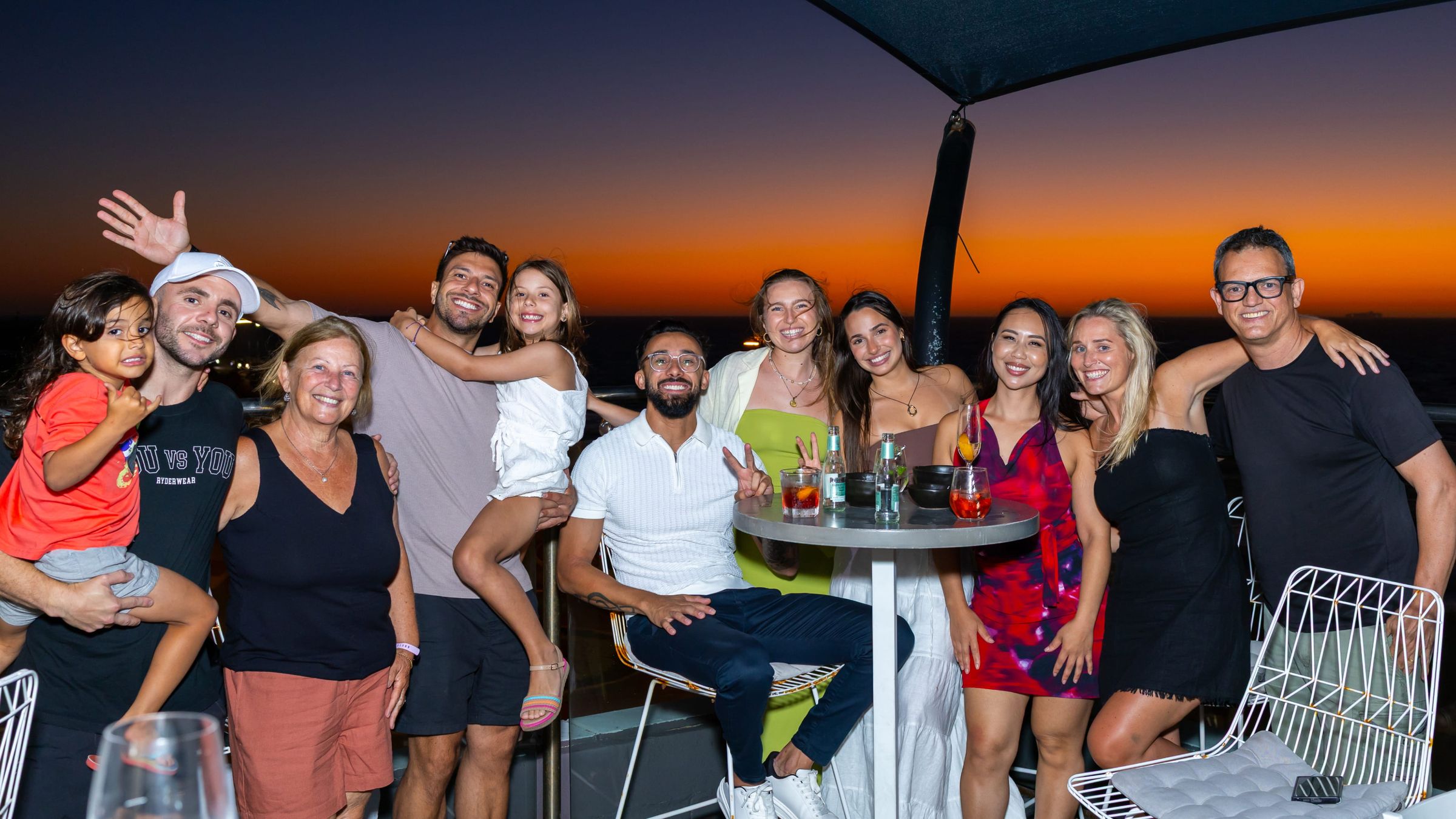A large group celebrating a function on the Tom's Italian terrace at sunset
