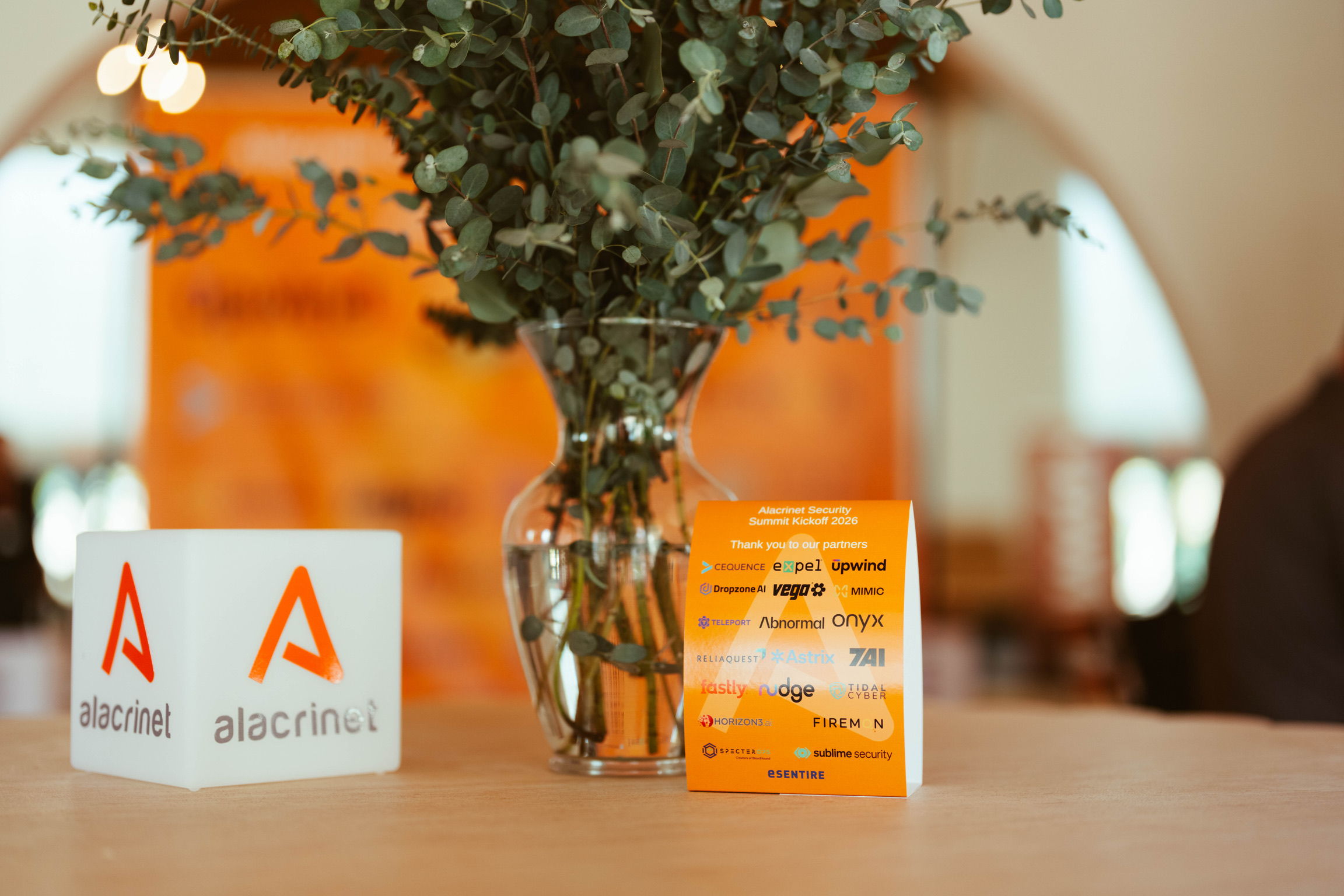 Alacrinet brand display and partner recognition card at the 2026 Security Summit
