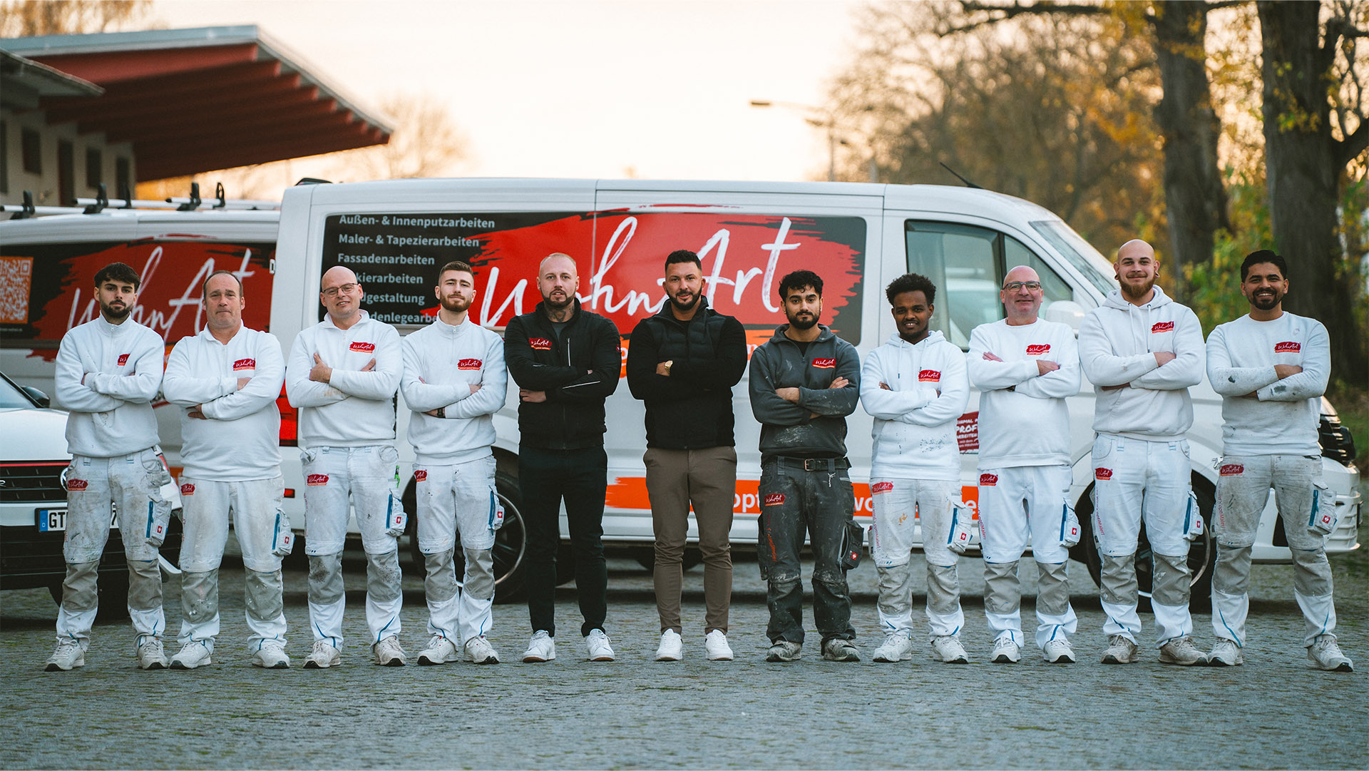 Team von WohnArt vor den Firmenfahrzeugen