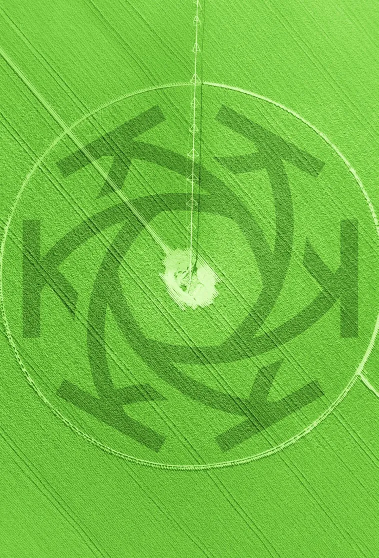 Aerial view of a green field with the Khonza mark mown into it
