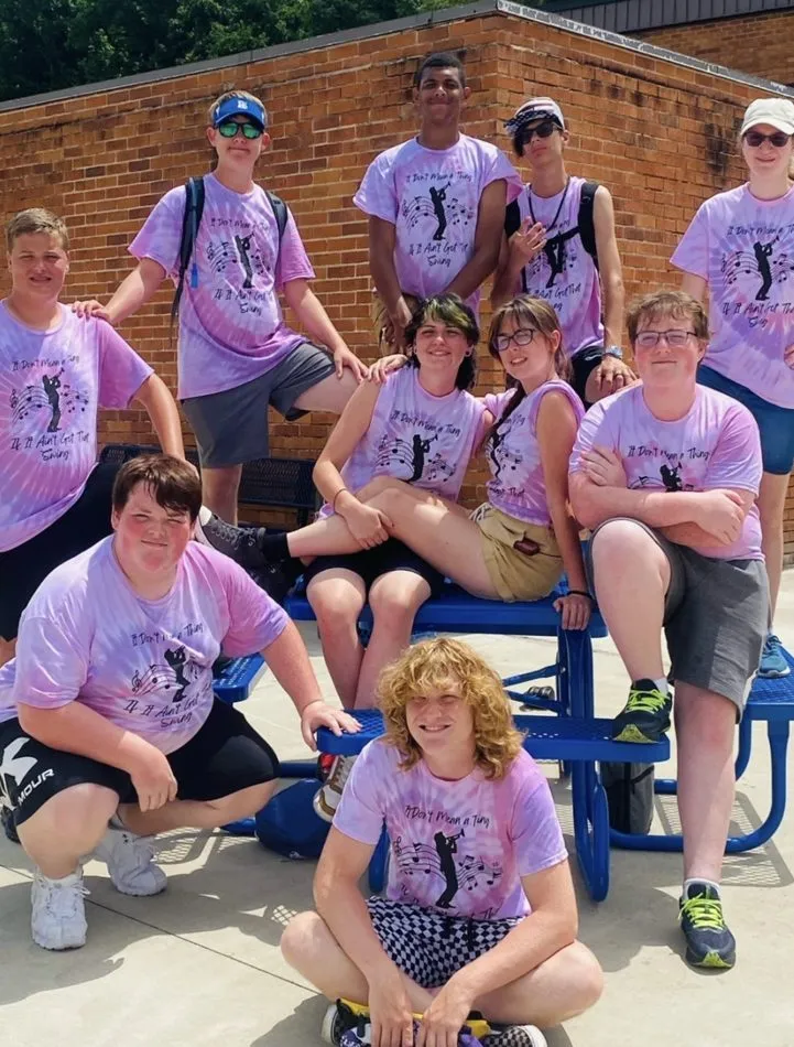 Group of teens in matching purple tie-dye shirts